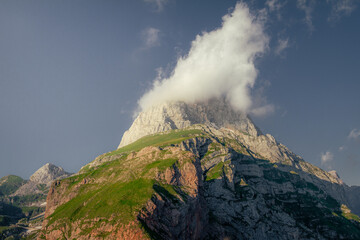 Slovenian mountain peak on Mangart touched by a playful cloud