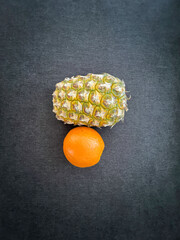 Pineapple orange fruit display on dark background