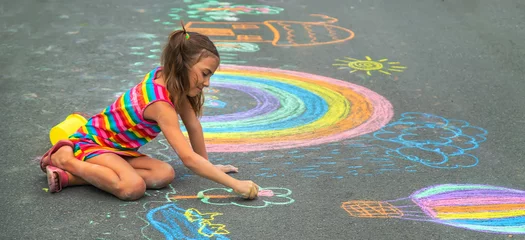 Foto op Plexiglas The child draws with chalk on the asphalt. Selective focus. © yanadjan