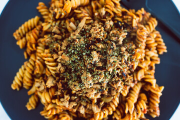 vegan red pesto fusilli pasta with marinated tofu topping, healthy plant-based food