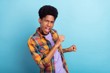 Photo of funny young brunet guy dance wear checkered shirt isolated on blue color background