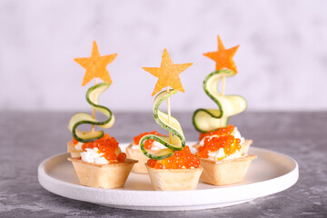 canapes with cheese, red caviar and cucumber herringbone