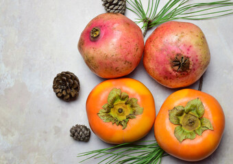 Top view, autumn fruit, persimmon and pomegranate, on marble background.