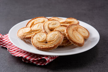 Palmier puff pastry in plate on black background