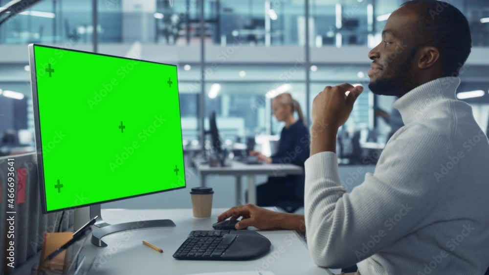 Leinwandbilder Diverse Modern Office: Handsome Black IT Technician Using Desktop Computer with Green Chroma Key Screen. Engineer Administrator Work on e-Commerce Development, Project Marketing, Big Data Analysis
