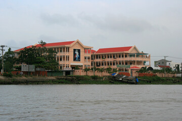 Fototapeta na wymiar building (church ?) along a river at the mekong delta in vietnam