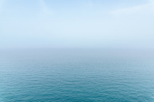 Abstract infinity sea view with small wave pattern and fog on horizon, clear sky in Puglia, Italy