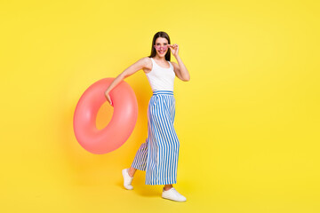 Full size photo of nice brunette lady hold buyou go wear top pants spactacles isolated on yellow color background