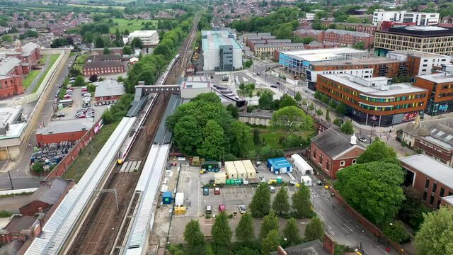 Aerial drone footage of the town centre of Wakefield in West Yorkshire in the UK showing a train going out of the main train station in the town.
