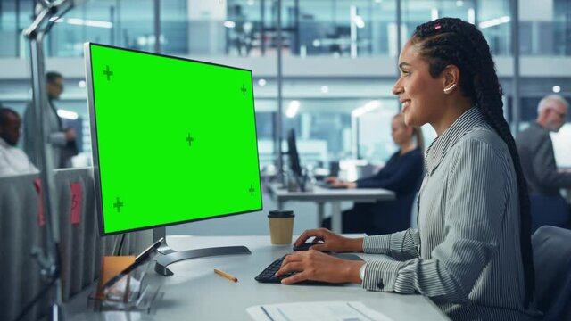 Diverse Corporate Office: Beautiful Black Female IT Technician Using Desktop Computer with Green Chroma Key Screen. Creative Software Engineer Work on eCommerce Project Marketing, Development