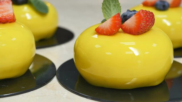 Detail, DOF, dolly shot. Yellow mousse mousse cakes with berry and mint. Premium desserts concept