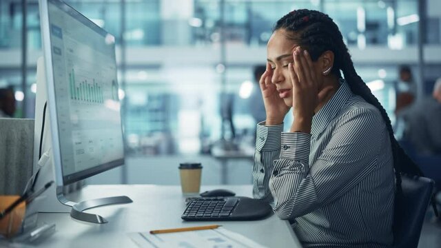 Black Female Corporate Office Worker Feels Stress, Sick, Frustration, Sick Works on Computer. Accountant Feeling Project Pressure, Has Headache Massages Her Head, Works with Statistics, Has Bad Day