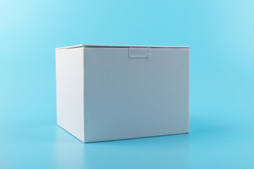 Opened white paper cube box on a blue background.