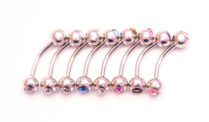 A set of jewelry for piercing on a white background. A set of earrings for the body, nose, navel, tongue, nipples, ears, various beauty jewelry, a set of cosmetological jewelry for piercing.