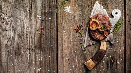 grilled fresh cross cut veal shank for making Osso Buco on meat cleaver. Long banner format. top view