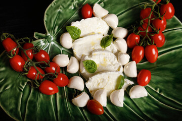 Mozzarella with cherry tomatoes on a green plate