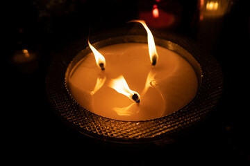 A flame of the candle. Candle burning brightly on dark background. Selective focus. 
