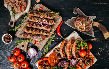 Delicious assortment of meat and vegetables grilling on a BBQ with pork sausages, minced beef meat kebabs, pork, beef. top view