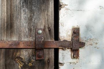 A wooden door with an old metal door latch