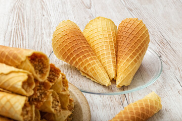 Wafer rolls and ice cream bags. Homemade cakes on a wooden table. Photo