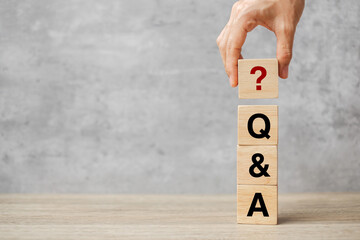 Hand holding Q and A word with wooden block. FAQ( frequency asked questions), Answer, Question  Ask, Information, Communication and Brainstorming Concepts