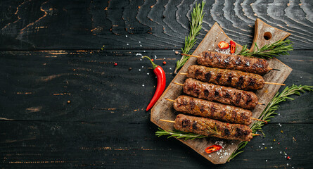 Lula kebab, traditional Caucasian dish. On the black background of the concrete, on a chopping...