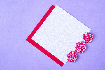 梅結びの水引と紅白の和紙（紫色の背景）