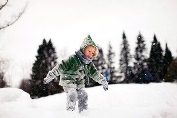 Fototapeta na wymiar Little Girl in Winter Coat Climbing the Snow Hill