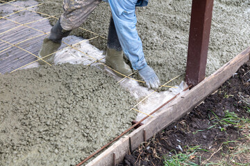 Workers level out the concrete mix at a construction site.