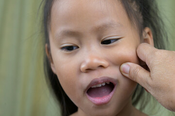Asian mother and child girl playing pinch cheeks, touch nose funny face.