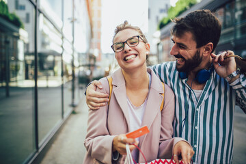 Young happy couple after shopping holding a credit card