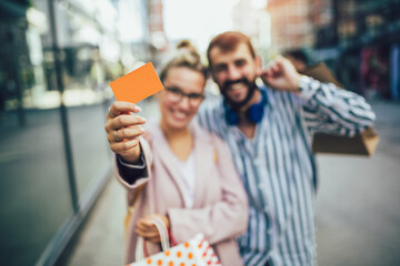 Young happy couple after shopping holding a credit card