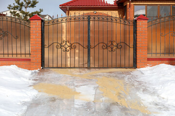 Snow at the gate with brick pillars.