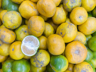 pile of oranges for sale with one peeled fruit as a sample