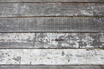 Closeup texture of the wooden floor of the terrace made of old faded white boards with scratches