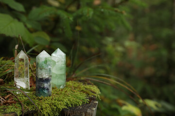Different crystals on moss in forest, space for text