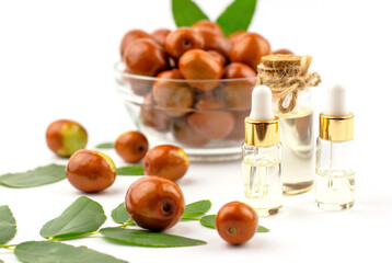 Jojoba oil in a bottle with a dropper and fresh jujube fruit