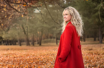 beautiful young girl in a red coat on a walk