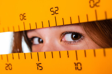eyes of kid girl with ruler measuring tool, size