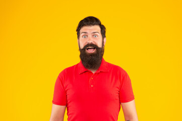 amazed bearded man with moustache in tshirt on yellow background, portrait