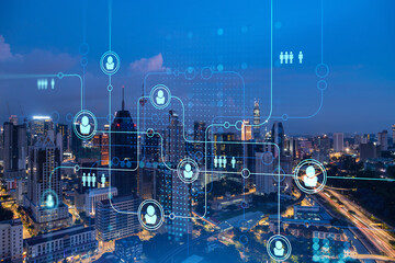 Glowing social media icons on night panoramic city view of Kuala Lumpur, Malaysia, Asia. The...