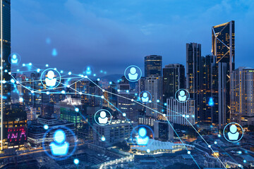 Glowing social media icons on night panoramic city view of Kuala Lumpur, Malaysia, Asia. The concept of networking and establishing new connections between people in businesses in KL. Double exposure.