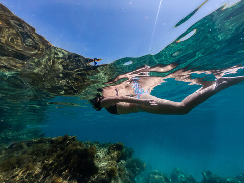 Woman snorkeling around coral reef. Underwater photo