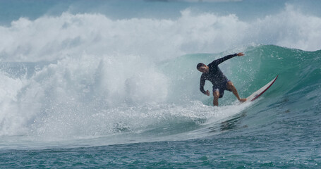 Surfer surfing tropical ocean wave attacking off the lip