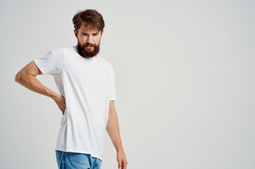 bearded man holding back arthritis health problems light background