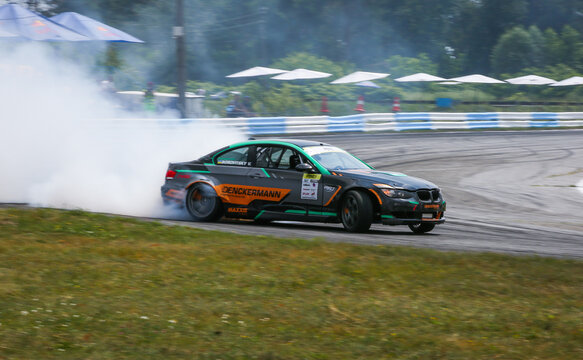 Kyiv, Ukraine - 4th of July 2021: Sports car BMW drifting, Blurred of image diffusion race drift car with lots of smoke from burning tires on speed track.