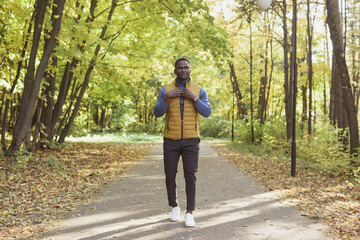 Hipster african american man walking in autumn park