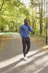 Hipster african american man walking in autumn park