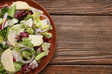 Delicious turnip salad served on wooden table, top view. Space for text