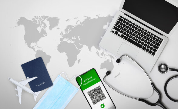 Green pass covid-19 vaccination concept for travel. Passport, face mask  and computer isolated on background with geographic world map. Vaccine certificate on smartphone screen with qr code.